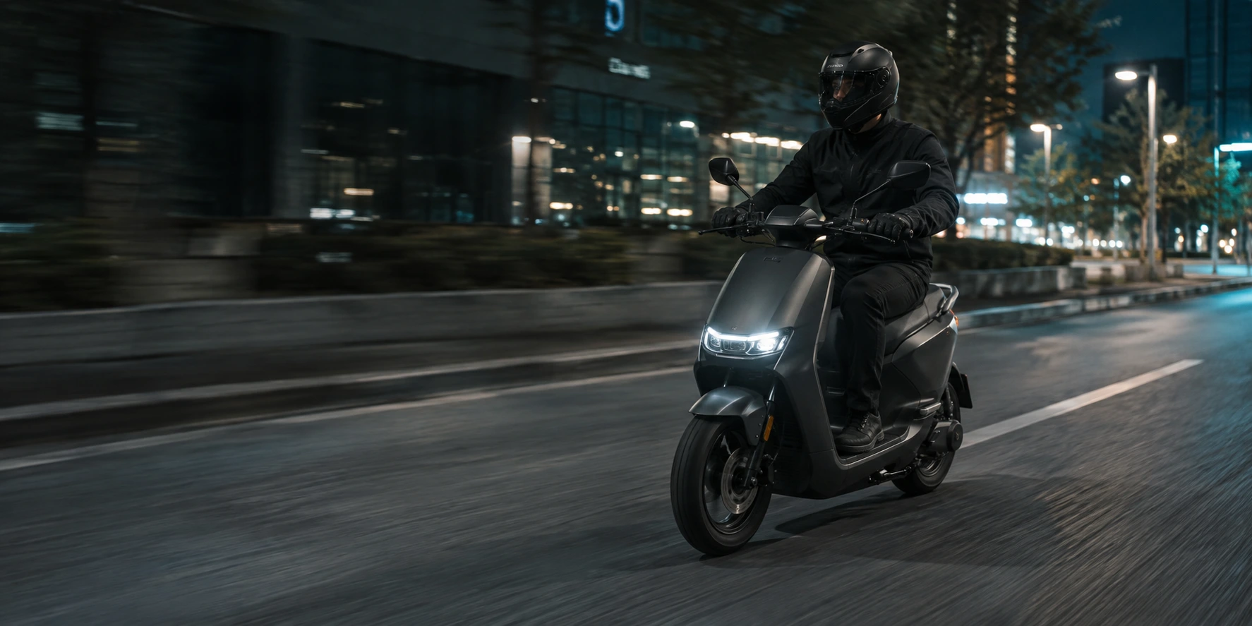 Pessoa com capacete pilotando uma scooter pela cidade ao anoitecer
